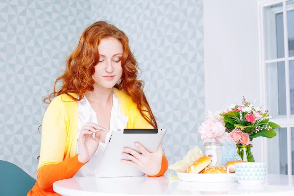 Piękna młoda kobieta za pomocą tabletu cyfrowego w kuchni — Zdjęcie stockowe