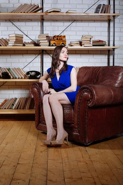 Portret van jonge brunette vrouw ontspannen op lederen fauteuil in — Stockfoto