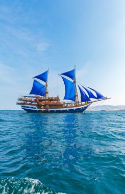 Vintage Wooden Ship with Blue Sails  clipart