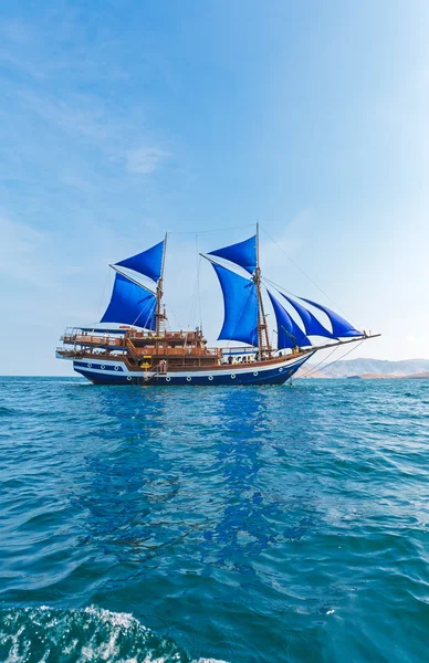Винтажное деревянное судно с голубыми парусами — стоковое фото