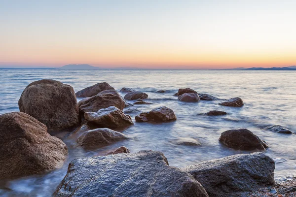 Paesaggio con rocce e onde al tramonto — Foto Stock