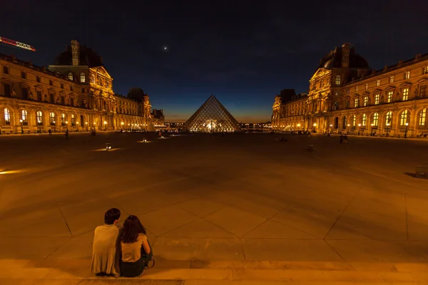 PARIS, FRANCE - APRIL 6, 2011: Couple seating in front of the Lo — ストック写真