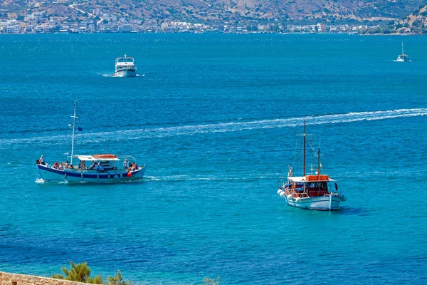 Många turistiska fartyg flyter i havet bay nära Spinalonga fortres — Stockfoto