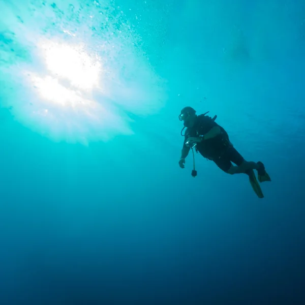 Silhouette of diver with sun disk — Stock Photo, Image