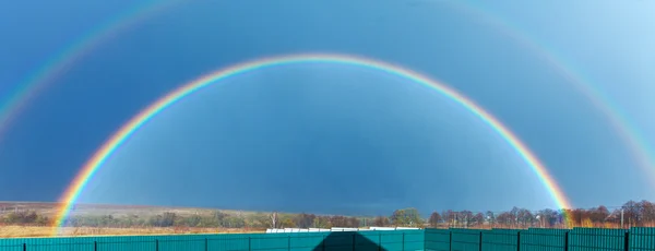 Hermoso arco iris completo sobre campo de granja en primavera — Foto de Stock