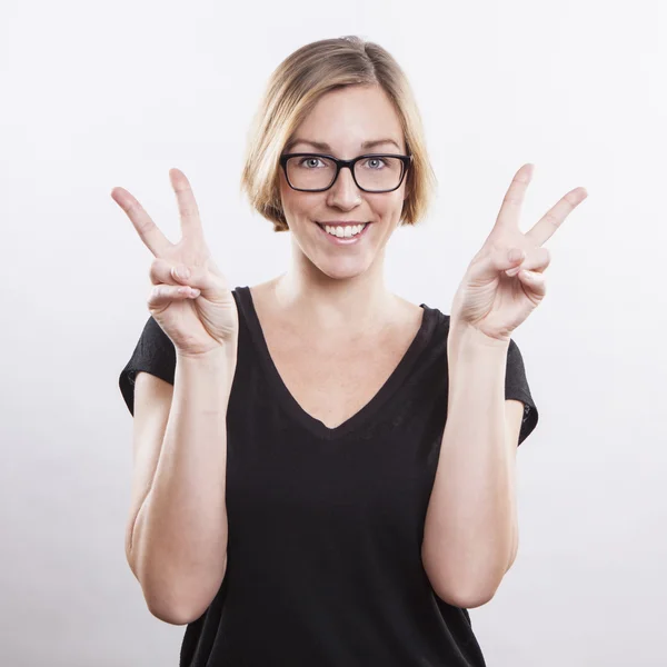 Bella giovane donna che fa un segno di vittoria — Foto Stock