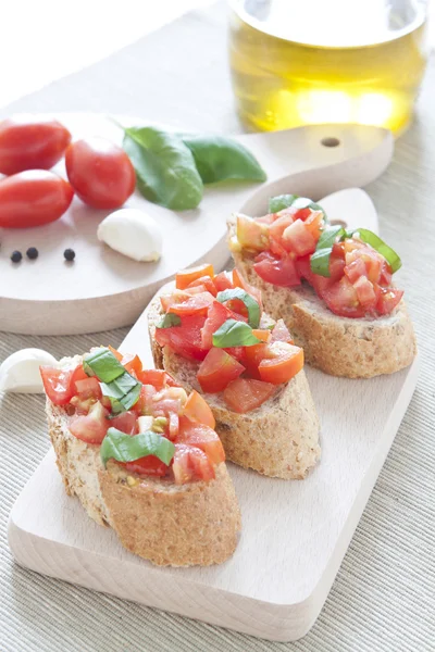 Crostini z pomidorów, olej, bazylią i czosnkiem — Zdjęcie stockowe