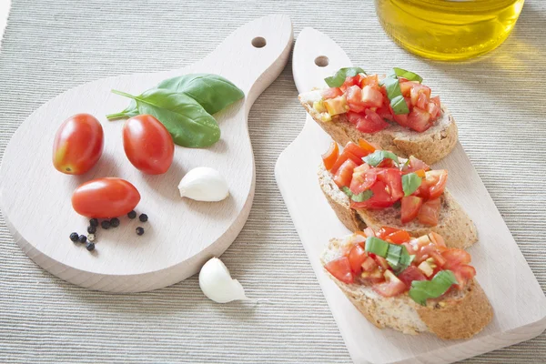 Crostini s rajčaty, olejem, bazalkou a česnekem — Stock fotografie