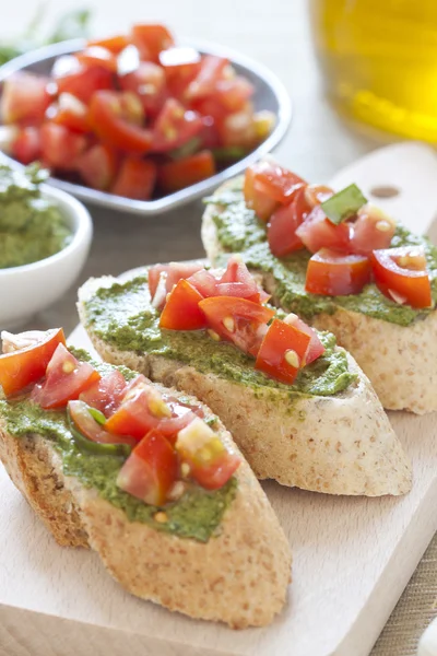 Crostini with arugula cream and tomatoes — Stock Photo, Image