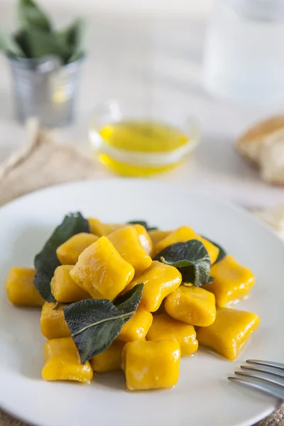 Delicious pumpkin gnocchi with sage leaves and olive oil, vegan — Stock Photo, Image