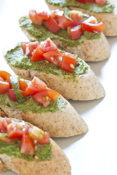 Crostini with arugula cream and tomatoes — Stock Photo, Image