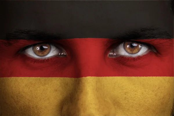 Γερμανία, η γερμανική σημαία ζωγραφισμένα στο πρόσωπο του νεαρού άνδρα — Φωτογραφία Αρχείου