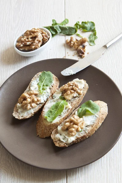 Crostini con queso gorgonzola, rúcula y nuez —  Fotos de Stock