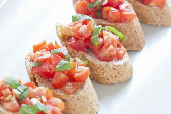 Crostini met tomaat, olie, basilicum en knoflook — Stockfoto