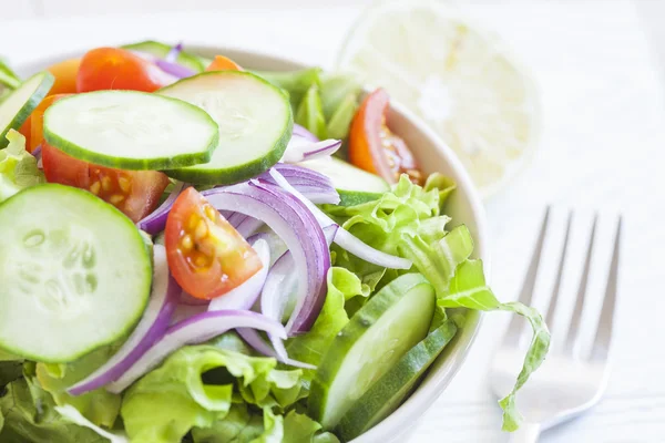 Fresh green salad with cucumber, tomato and red onion. — Stock Photo, Image