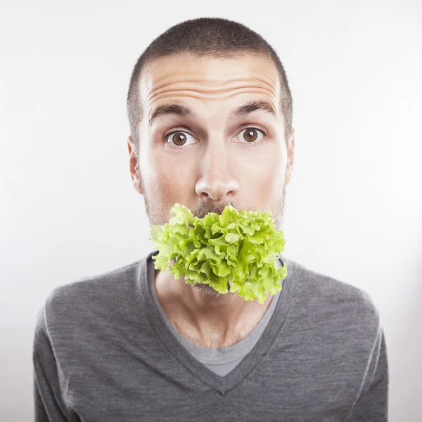 Young man with lettace in his mouth — Stock Photo, Image