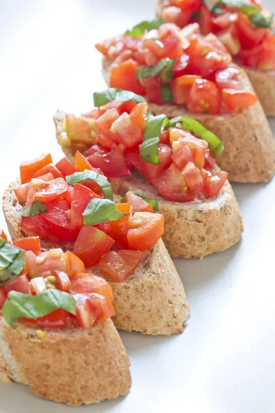 Crostini s rajčaty, olejem, bazalkou a česnekem — Stock fotografie