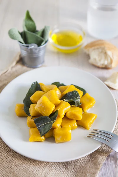 Delicious pumpkin gnocchi with sage leaves and olive oil, vegan — Stock Photo, Image