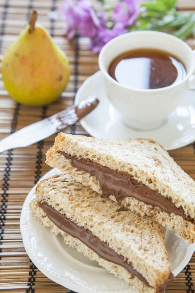 Pão torrado com chocolate cremoso e chá, delicioso café da manhã — Fotografia de Stock