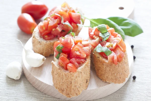 Crostini con tomate, aceite, albahaca y ajo —  Fotos de Stock