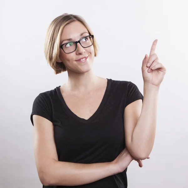 Mujer joven señalando hacia arriba — Foto de Stock