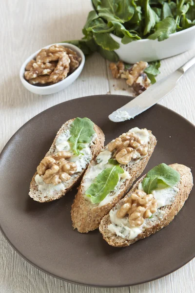 Crostini con queso gorgonzola, rúcula y nuez —  Fotos de Stock