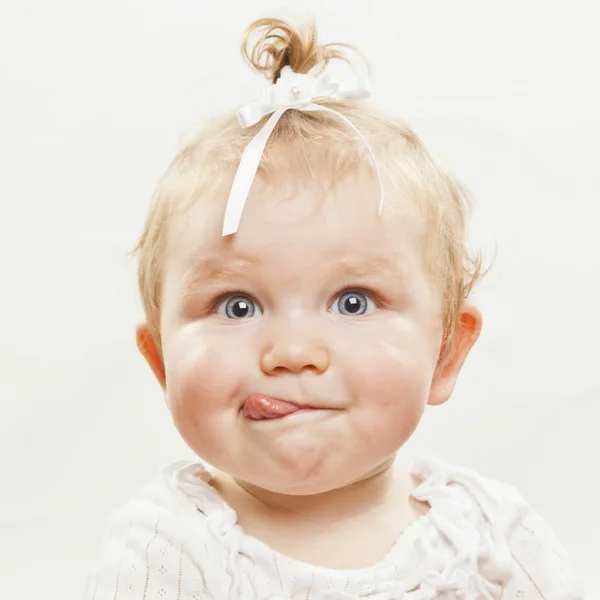 Adorável bebê menina com língua saindo — Fotografia de Stock