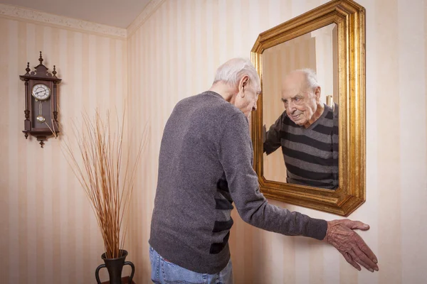 Älterer Mann blickt in Spiegel — Stockfoto