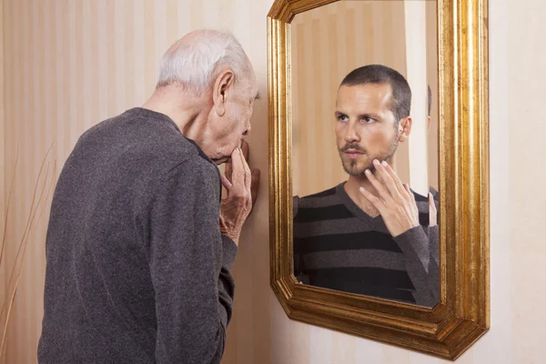 Old man looking at young himself — Stock Photo, Image