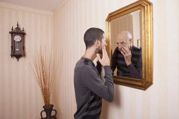 Man looking at older himself — Stock Photo, Image
