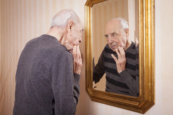 Anziano uomo guardando specchio — Foto Stock