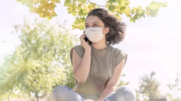 Ung Kvinna Med Ansiktsmask Som Pratar Telefon Utanför Normal Efter Royaltyfria Stockfoton