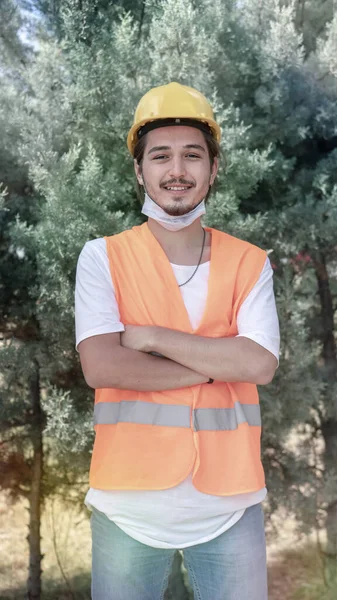 Fiatal Férfi Építőmunkás Portréja Sárga Sisakkal Arcmaszkkal Keresztbe Tett Karokkal Jogdíjmentes Stock Fotók