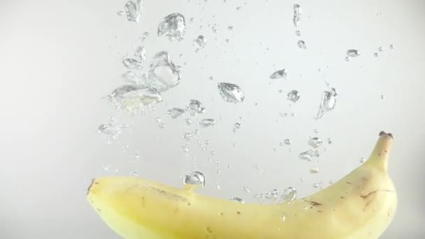 바나나 속으로 뛰어들어 물거품과 천천히 열매는 바탕에 흰색으로 표시되어 프레임 — 비디오