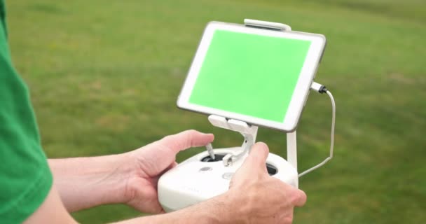 Člověk používá Rc řadič pro Uav Drone mimo zelenou obrazovku tabletu — Stock video