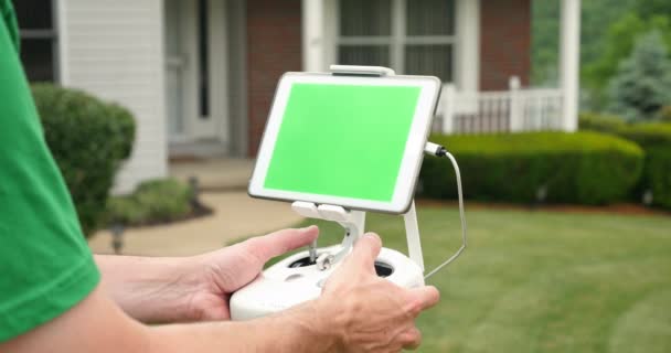 Bastler verwendet Remote Control für Drohne außerhalb eine Haus-Green-Screen-Tablette — Stockvideo