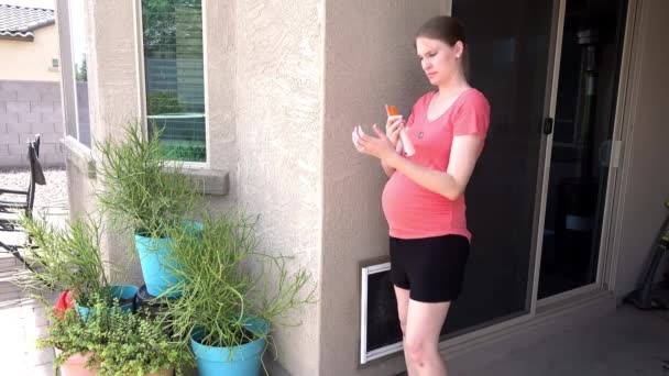 Jeune femme enceinte pulvérise Bug Spray sur elle-même avant de sortir à l'extérieur — Video