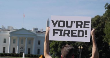 A man holds a YOU'RE FIRED! protest sign outside the White House. People gathered outside The White House after Joe Biden defeated Donald Trump in the 2020 Presidential election.   clipart