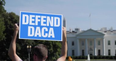 WASHINGTON DC - Haziran 2020 - Beyaz Saray 'ın dışında bir adam DEFEND DACA protesto tabelası tutuyor.