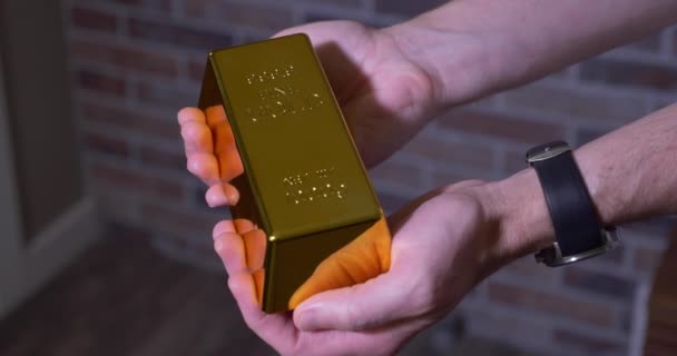 Człowiek trzyma jedną sztabkę złota — Wideo stockowe