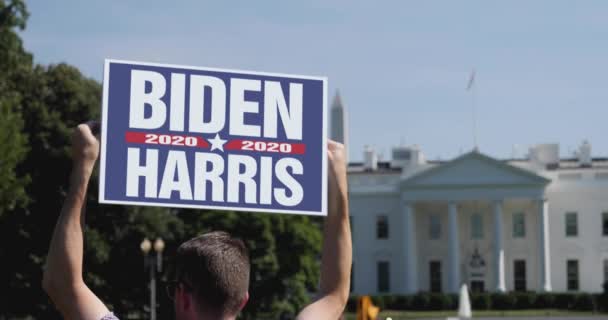 Знак "Человек держит Байдена Харриса 2020" перед Белым домом — стоковое видео