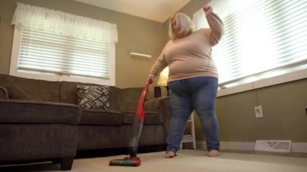 Niski kąt widzenia kobiety Vacuuming podczas tańca — Wideo stockowe