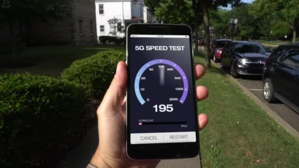 Hombre prueba velocidades de descarga 5G en el teléfono inteligente en la ciudad pequeña — Vídeo de stock