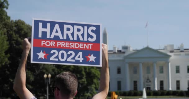 Man innehar Kamala Harris 2024 Logga in framför Vita huset — Stockvideo