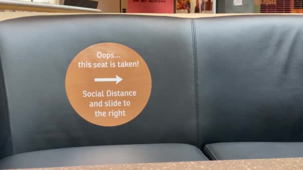 Man Sits Mall Couch Next Empty Seat Social Distance Reminder — Stock Video