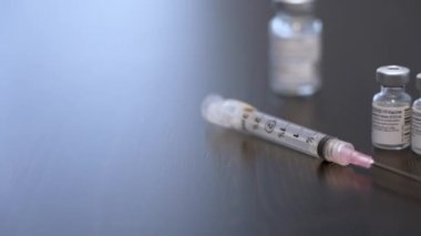 Mart 2021 - Pfizer aşı şişesinin sürgülü bir resmi. Bir doktor, hemşire ya da eczacı şırıngayı alır..  