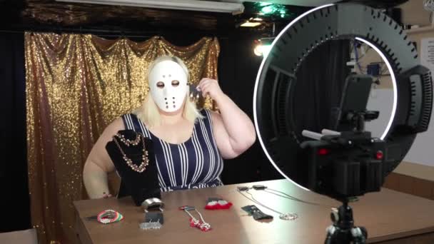 一名戴着冰球面具的女子在社交媒体视频流频道上出售珠宝 — 图库视频影像