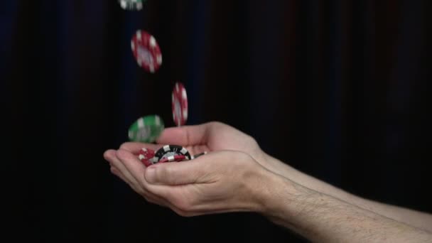 カジノゲームチップは スローモーションで男の手に落ちます 120Fpsで撮影 チップは一般的であり 特定のカジノを表すものではありません 黒リンボの背景 — ストック動画