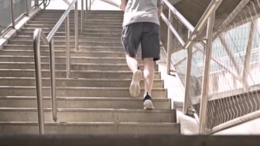 Bir yeraltı metro istasyonundan çıkan bir yayanın alçak açılı görüntüsü.  