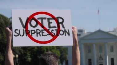 WASHINGTON, DC - Takriben Mart 2021 - Bir adam Beyaz Saray 'ın önünde el yapımı DUR OYUNU protestosu işareti sallıyor.  